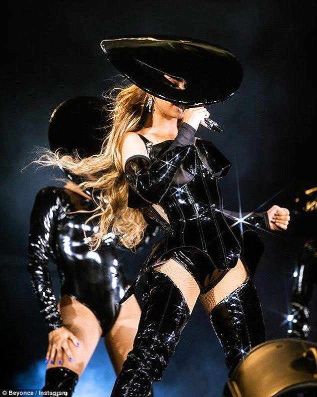 Beyonce performing in all black outfit with a large hat